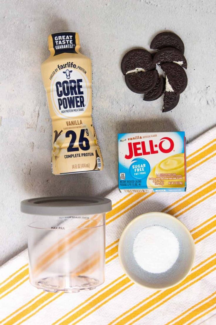 ingredients to make oreo cookies laid out on a striped table cloth with an orange and white towel