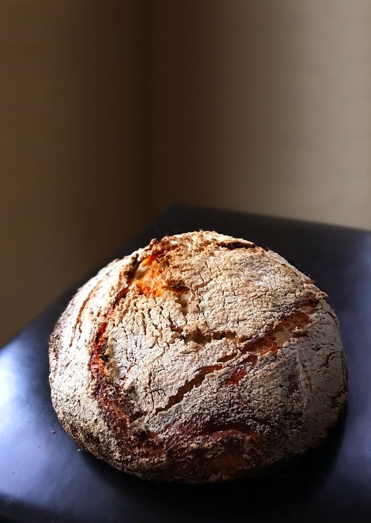 a loaf of bread sitting on top of a black table next to a window sill