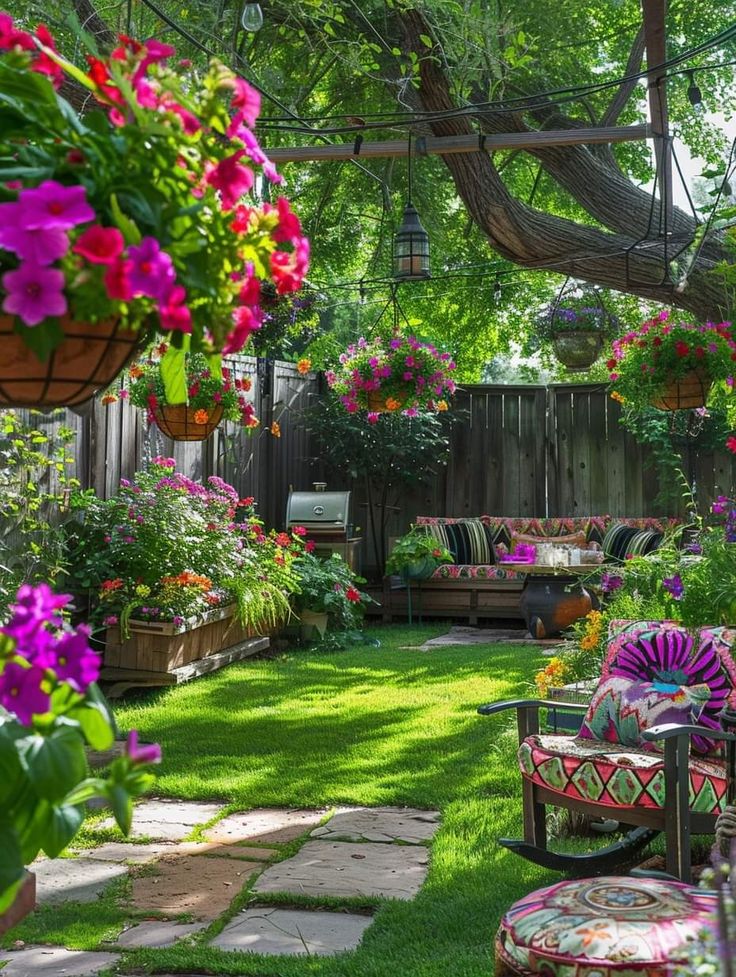 an outdoor patio with lots of flowers and plants on the grass, surrounded by potted trees