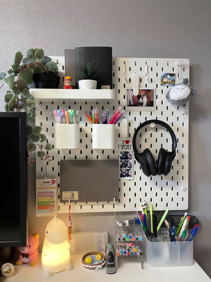 a computer desk with headphones, books and other office supplies on it's wall