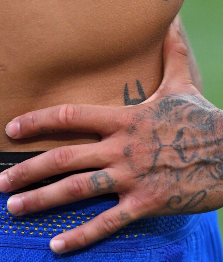 a close up of a person's stomach with tattoos on his arm and hand