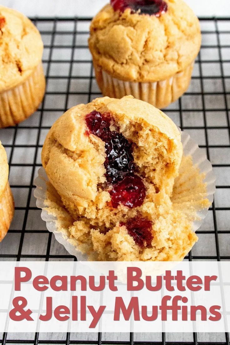 three muffins with cranberry filling sitting on a cooling rack next to each other