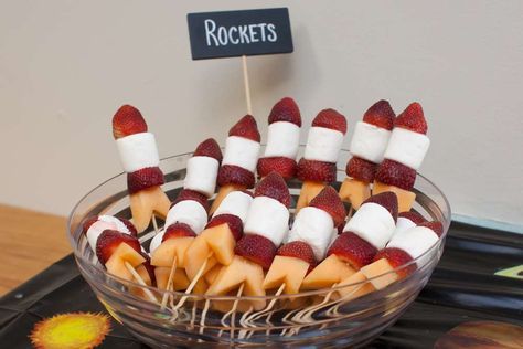 strawberries and marshmallows are arranged on sticks in a bowl