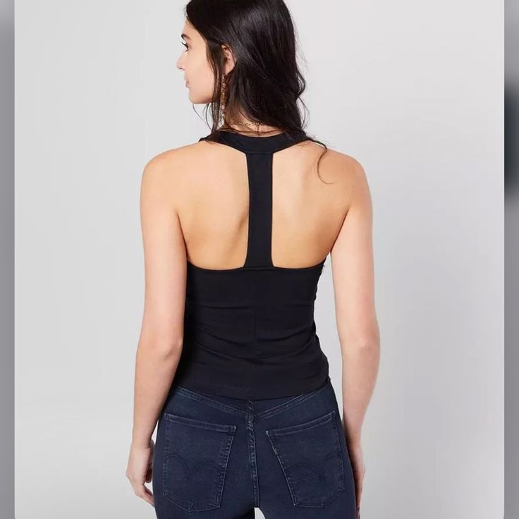 Solid T-Back Tank Material: 67% Viscose 28% Nylon 5% Elastane Measurements: Pit To Pit: 16” Length: 22.5” Chic Black Racerback Top, Chic Black Tops For Yoga, Chic Black Yoga Top, Chic Workout Tops, Purple Sequin Top, Sleeveless High Neck Blouse, Striped Peplum Top, Sheer Long Sleeve Top, Varsity Sweater