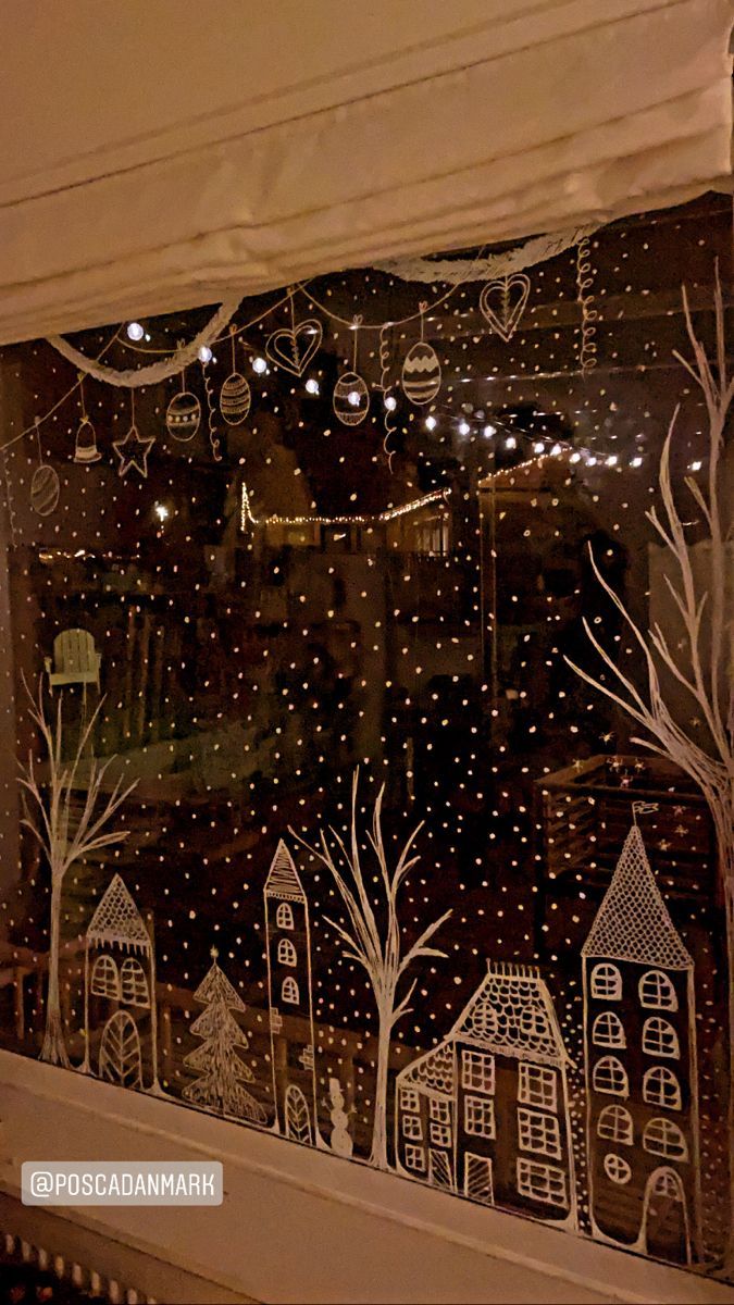 the window is decorated with christmas lights and houses