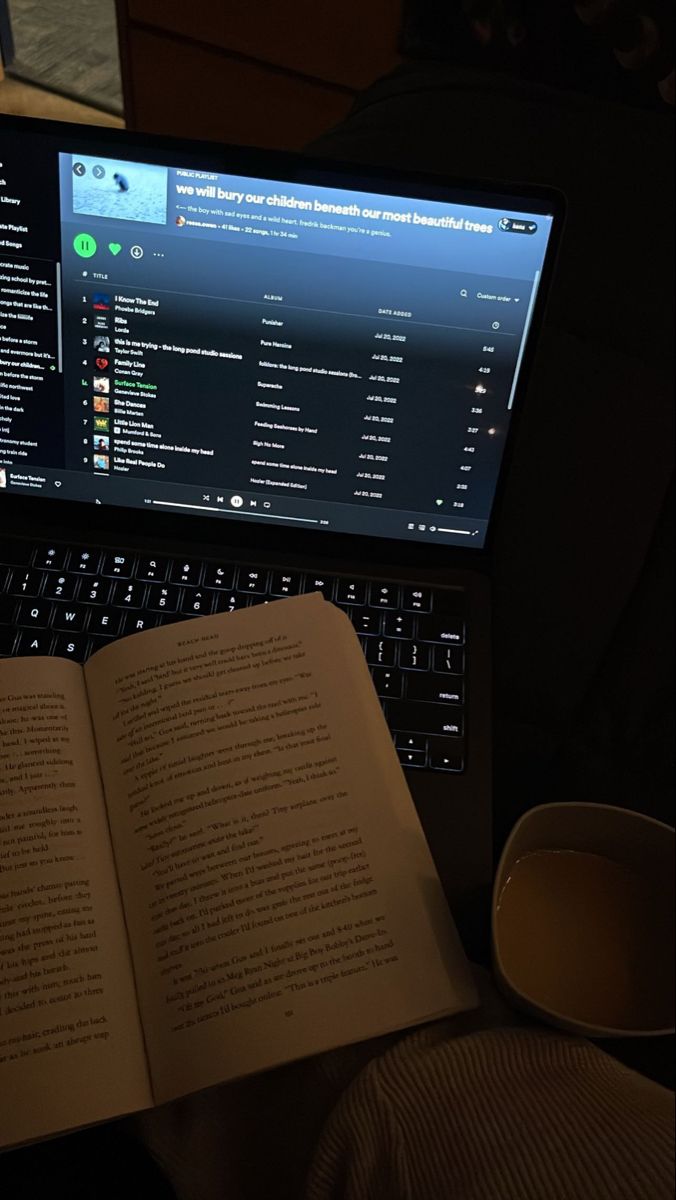 an open book sitting on top of a laptop computer