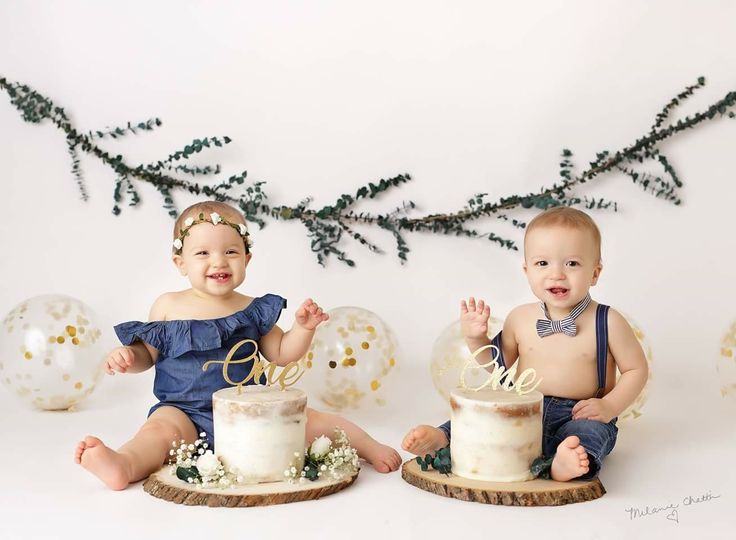 two babies sitting next to each other with cake