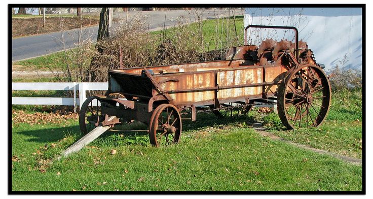 an old rusty wagon sitting in the grass