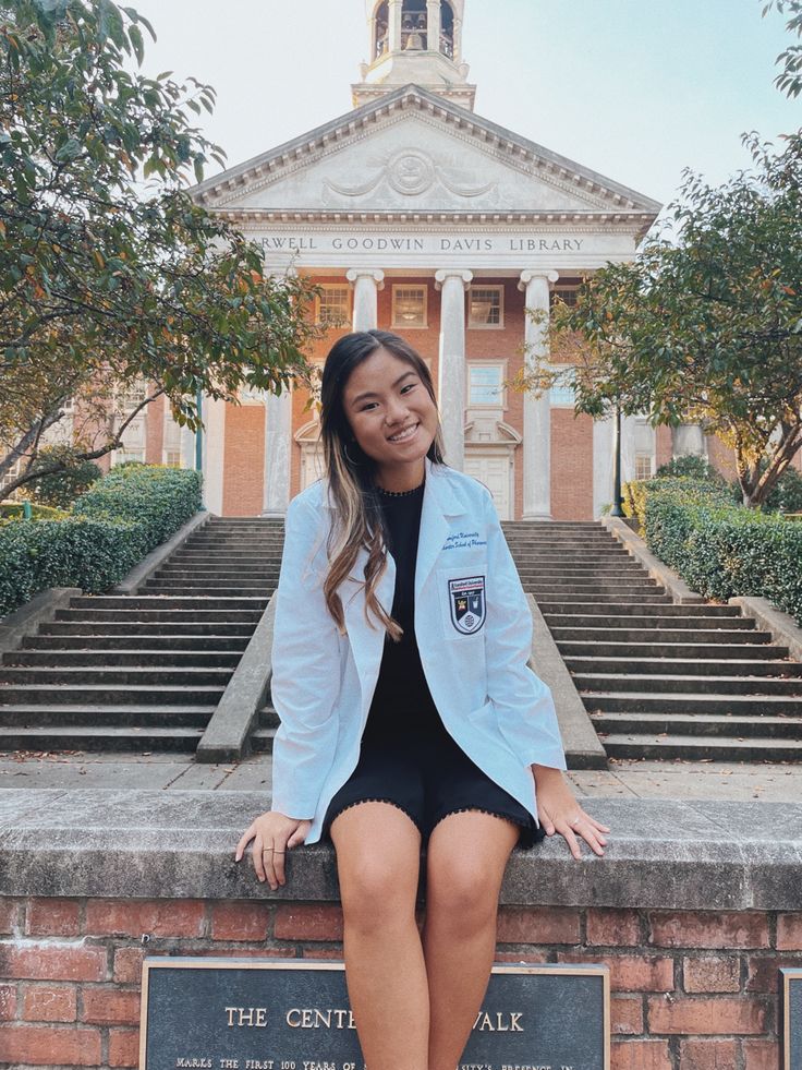 a young woman sitting on the steps in front of a building