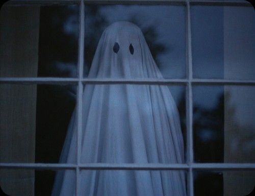 a ghost is seen through the window of a house