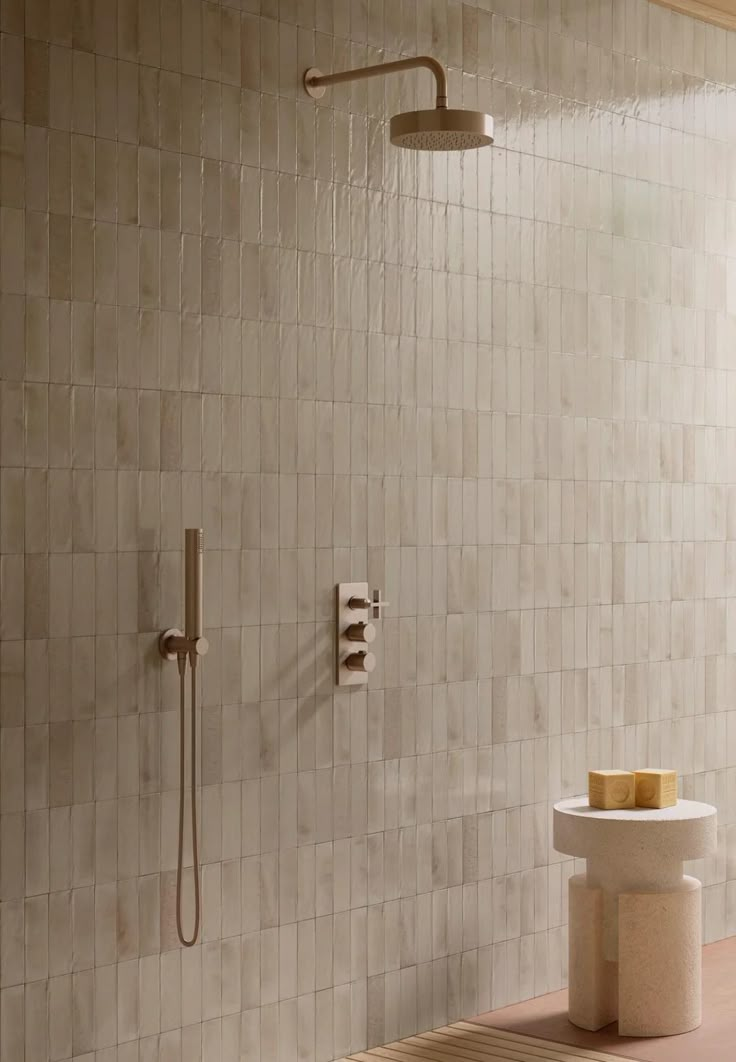 a bathroom with a shower head, soap dispenser and standup shower