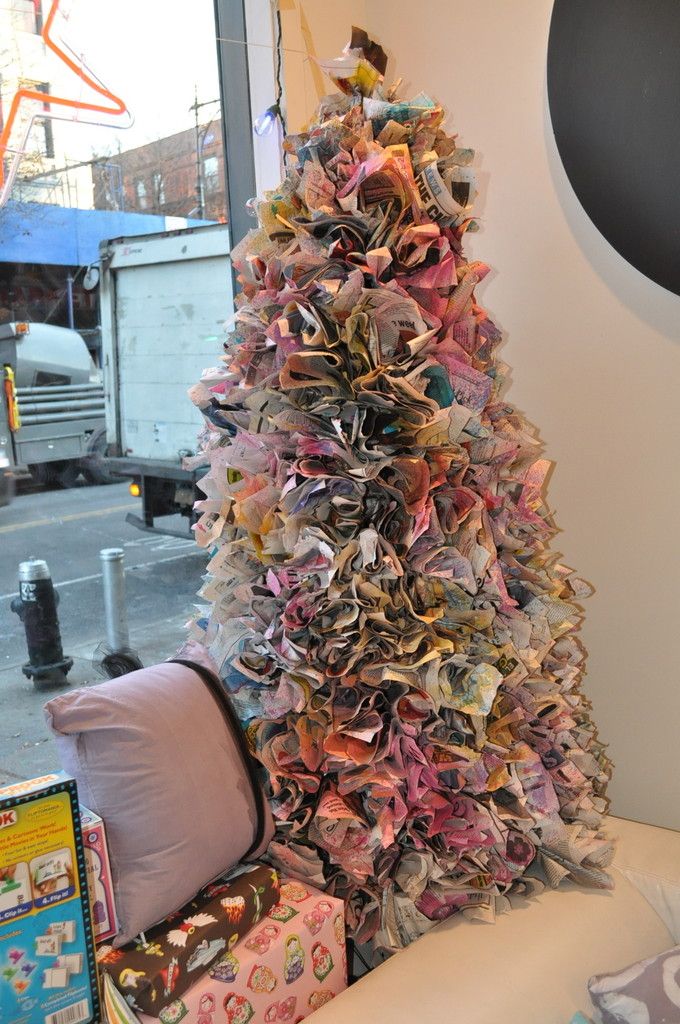 a christmas tree made out of books in front of a window