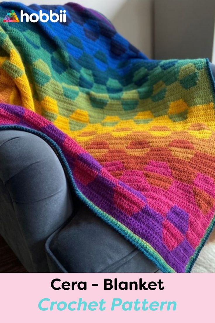 a colorful crochet blanket sitting on top of a couch next to a window