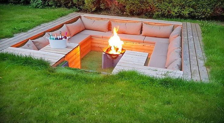 a fire pit in the middle of some grass