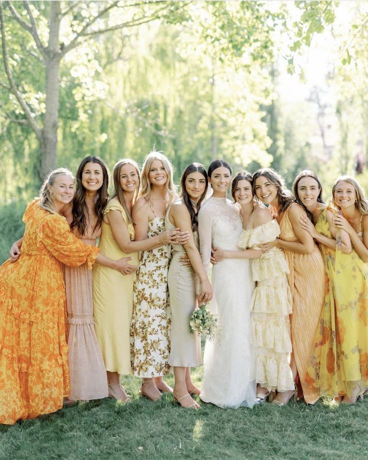 a group of women standing next to each other on top of a lush green field