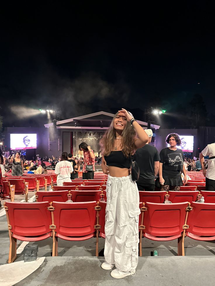 a woman standing in front of red chairs