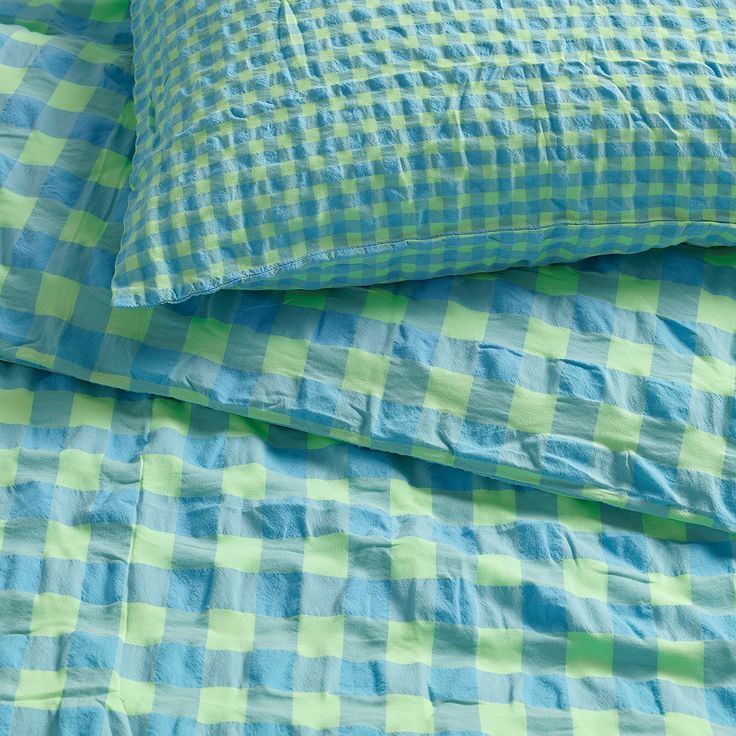 a blue and green checkered bed spread with two pillows