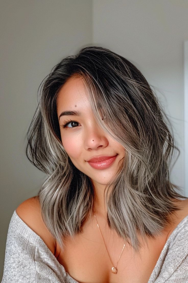 Black hair with grey highlights? We're obsessed! If you're looking for grey blending ideas, check out over 40 beautiful examples of dark hair with silver highlights on our blog. From subtle grey balayage to striking grey ombre, we've got all the inspo you need. Click to view all the ideas now and save this pin for later! Best Way To Blend Gray Hair Dark Brown, Brown Hair With Gray Money Piece, Black Hair Going Grey, Grey Blending Dark Hair, Hair With Grey Highlights, Blending Greys Into Brown Hair, Gray Blending Hair Dark Brown, Grey Blending Highlights Dark Brown, Grey Highlights On Dark Hair