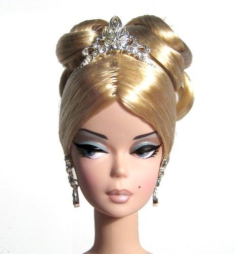 a barbie doll with blonde hair wearing a tiara and earrings on it's head