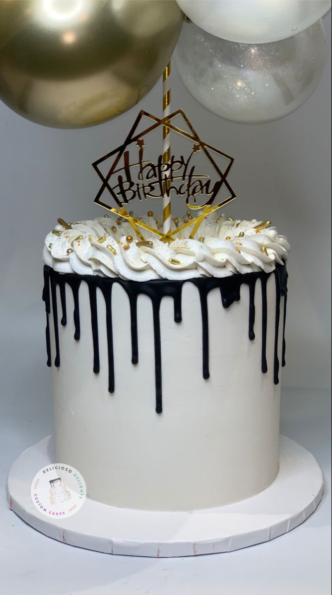 a birthday cake with white frosting and black icing dripping down the side, surrounded by balloons