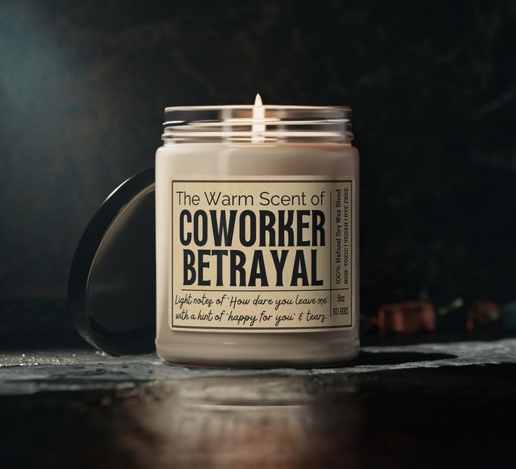 a candle is sitting on a table with the words, the warm scent of coworker betrayal