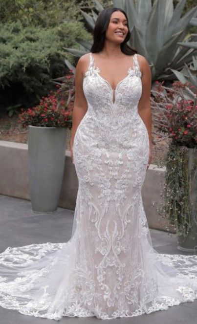 a woman in a white wedding dress standing on a patio with cacti and succulents behind her