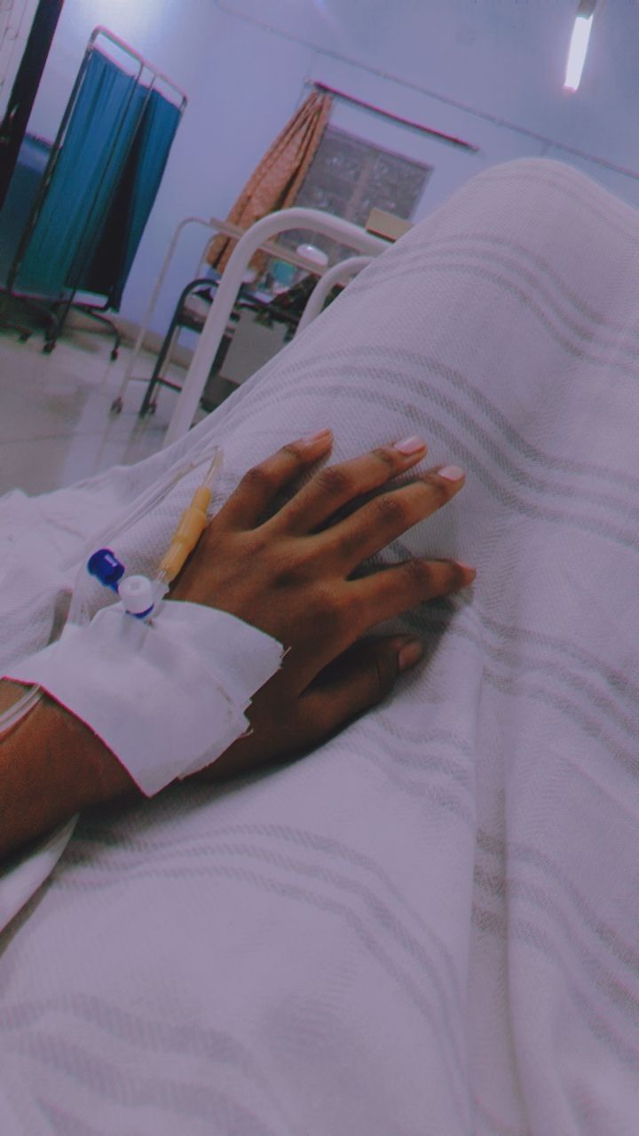 a person laying in a hospital bed with an iv attached to their arm and hand