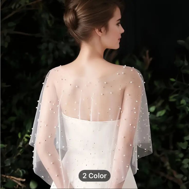 the back of a woman's wedding dress with pearls on it