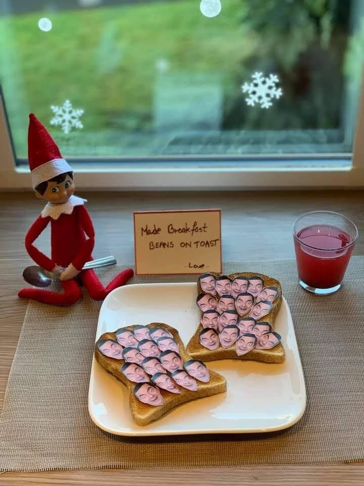 an elf is sitting next to some cookies on a plate