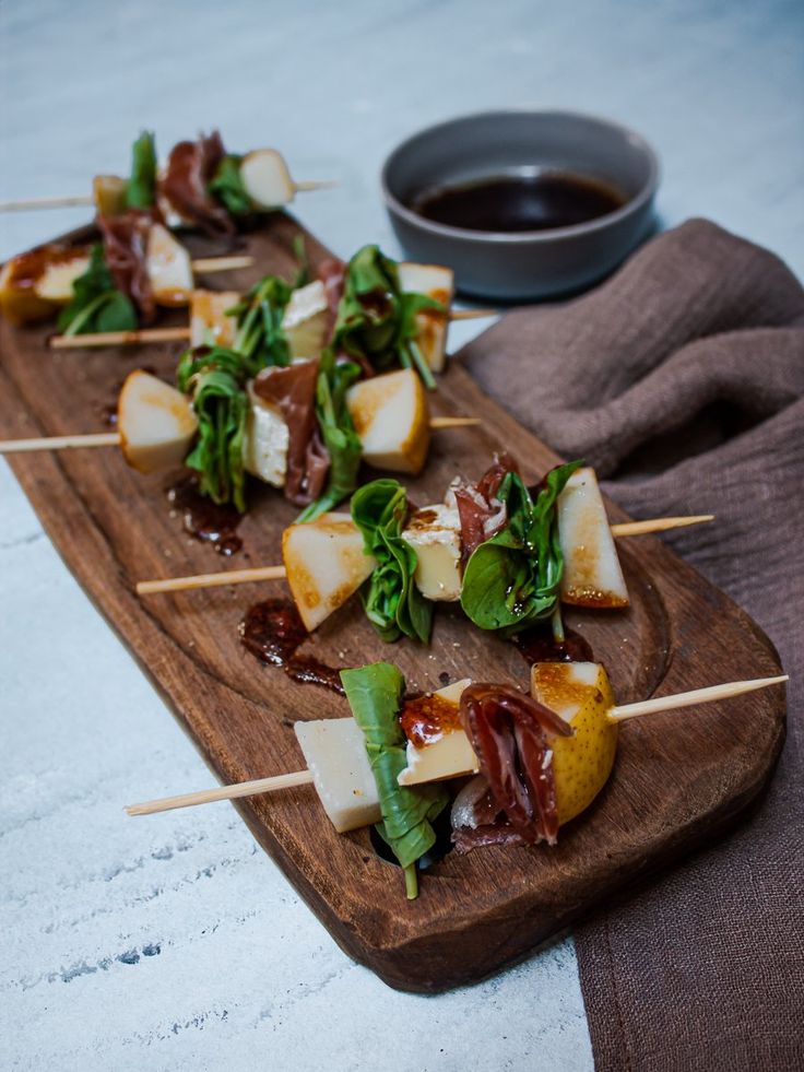 several skewered food items on a wooden cutting board