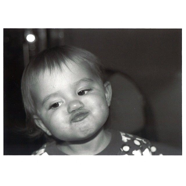 a black and white photo of a toddler smiling