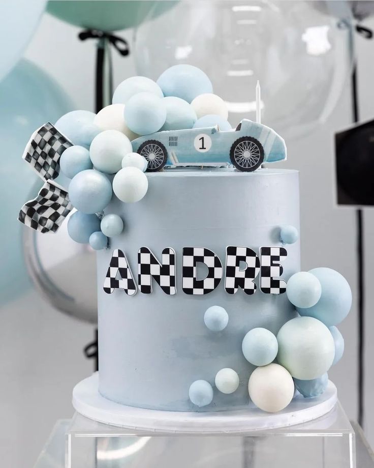 a blue and white birthday cake with a car decoration on the top that says race