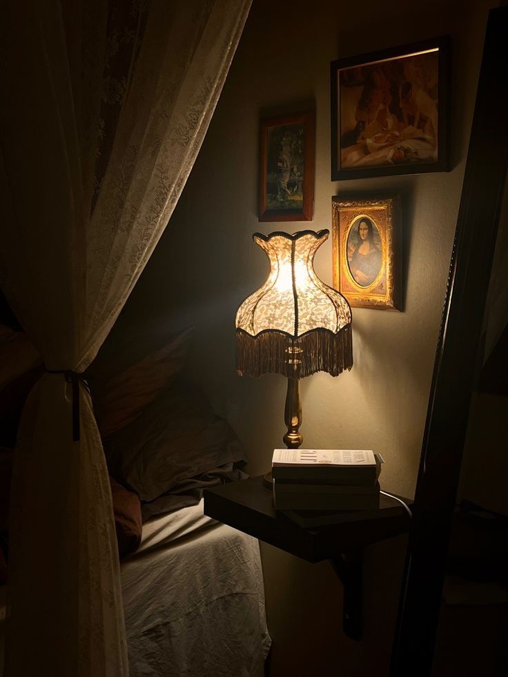 a lamp sitting on top of a table next to a bed