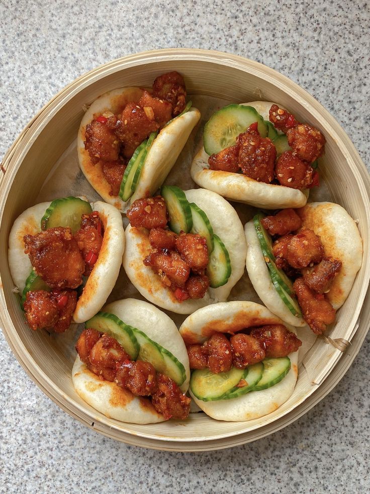 small dumplings with meat and cucumbers in a wooden bowl on a table