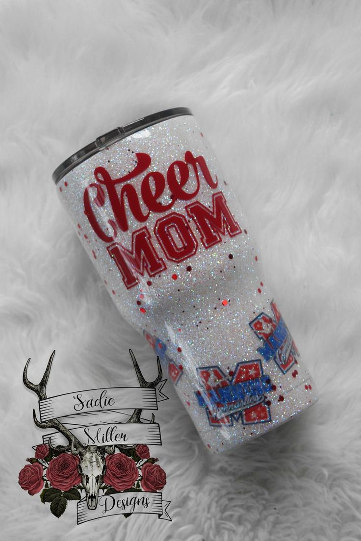 a white tumbler with the word cheer mom on it next to some antlers