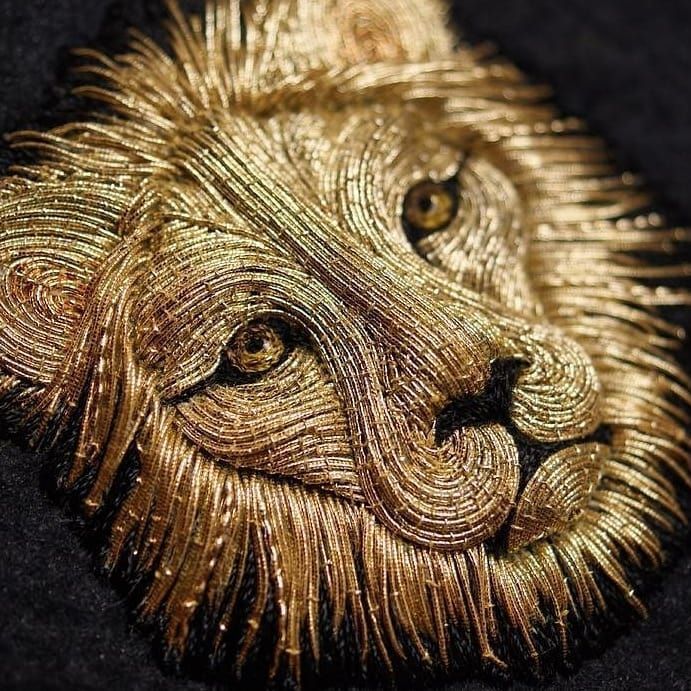 a close up of an animal made out of gold thread