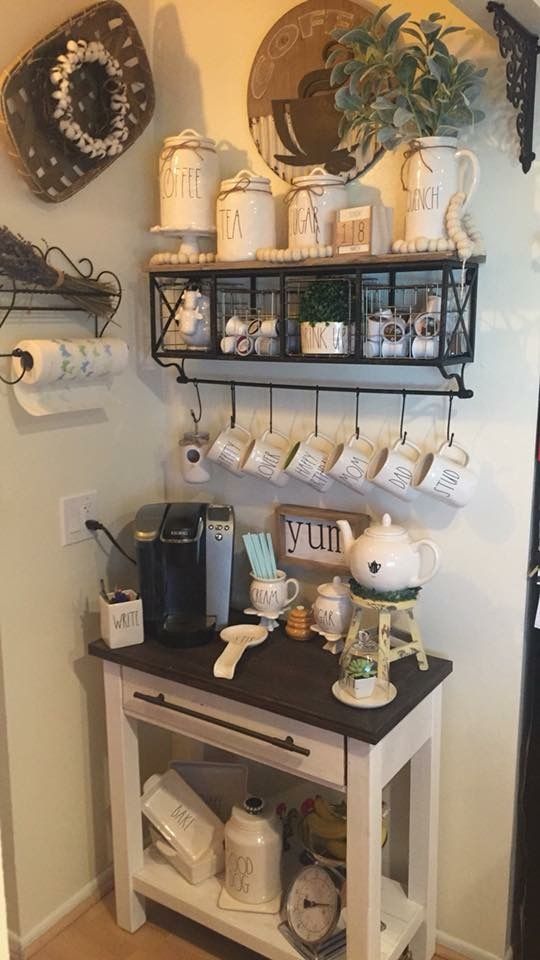 there is a small table with coffee cups on it and some shelves above the counter