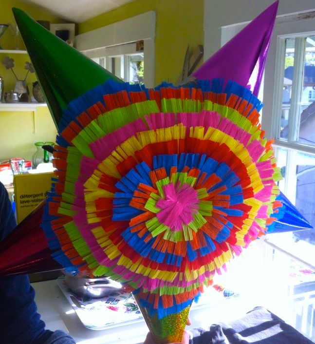 a large colorful umbrella sitting on top of a table next to a book shelf and window