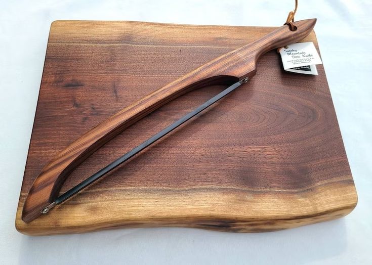 a wooden cutting board with a knife and some sort of tool on top of it