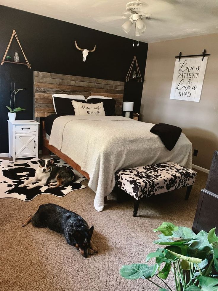 a dog laying on the floor next to a bed in a room with black and white decor