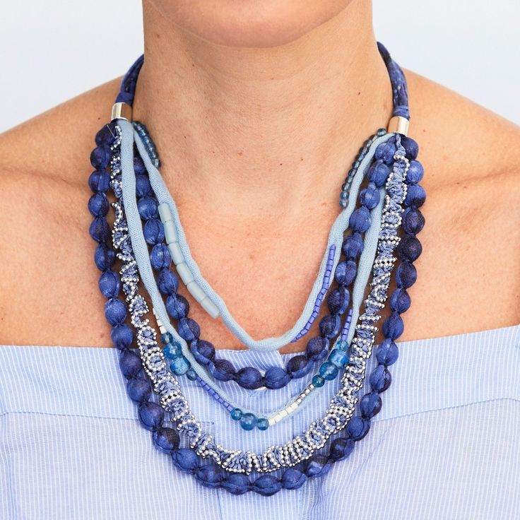 Chunky blue necklace is made up of bead and cloth pieces that vary in size and color. It is made from metal and fabric. It measures 18" with a 5"drop and a 4" extender Blue Wooden Beads For Festival, Blue Jewelry With Wooden Beads, Blue Multi-strand Wooden Bead Necklaces, Blue Large Beads Necklace, Blue Wooden Beads Festival Jewelry, Blue Wooden Beads Jewelry For Festival, Adjustable Blue Necklace With Wooden Beads, Blue Bib Necklace With Large Beads, Blue Beaded Necklace With Large Beads For Festival