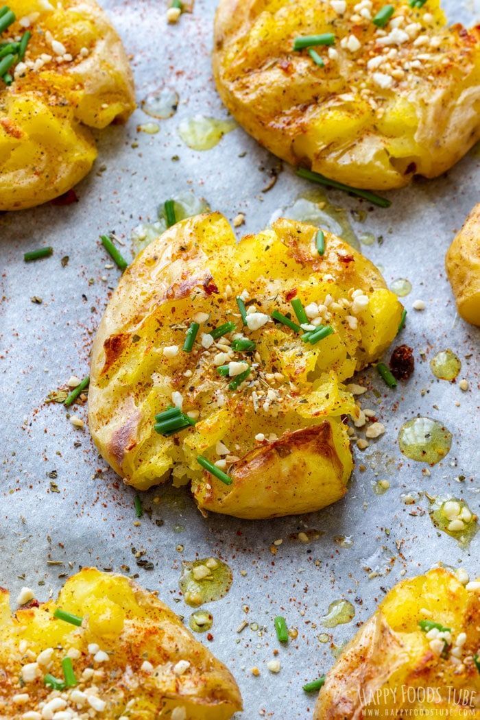 baked potatoes with herbs and seasoning on a baking sheet, ready to be eaten