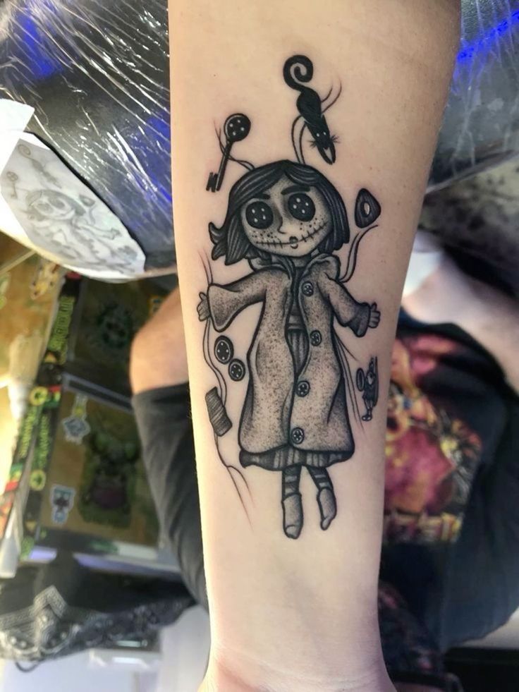 a tattoo with a girl in a coat on her arm and an arrow above her head