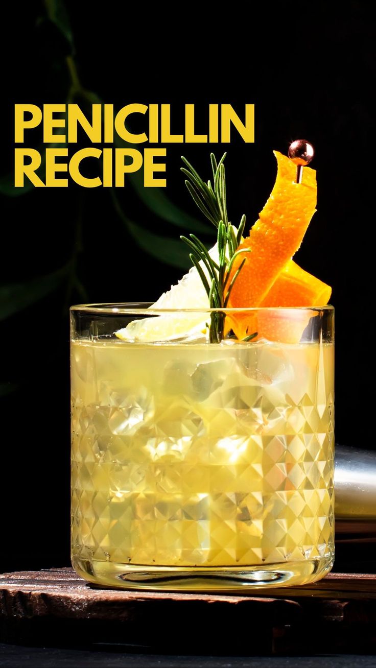 a glass filled with ice and orange peels on top of a wooden cutting board