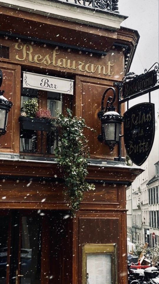 an old building with snow falling on it