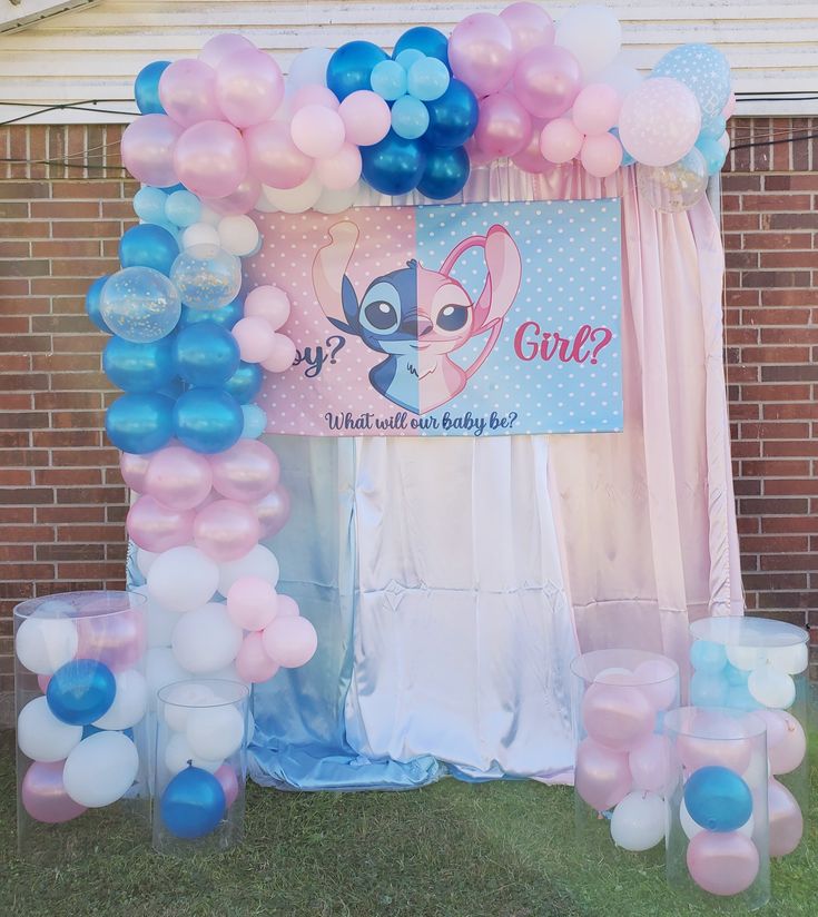 the balloon arch is decorated with pink, blue and white balloons for a baby shower