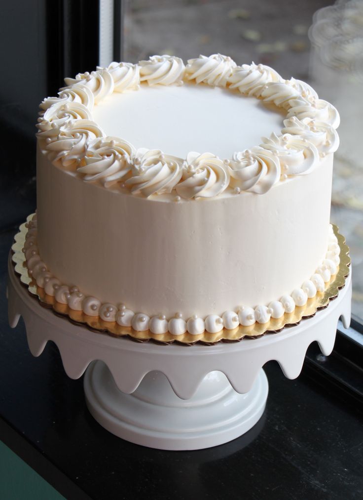 a white frosted cake sitting on top of a window sill