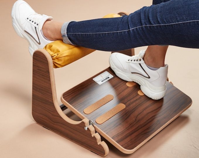 a person is standing on top of a wooden chair with their feet on the stool