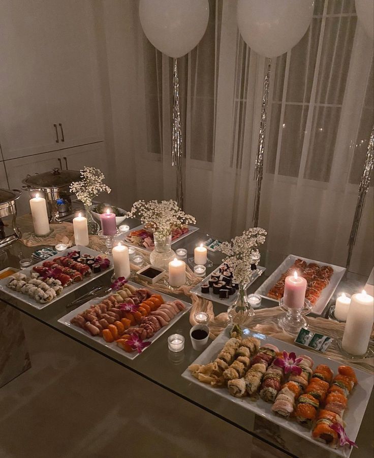 a table filled with lots of different types of donuts and desserts next to candles