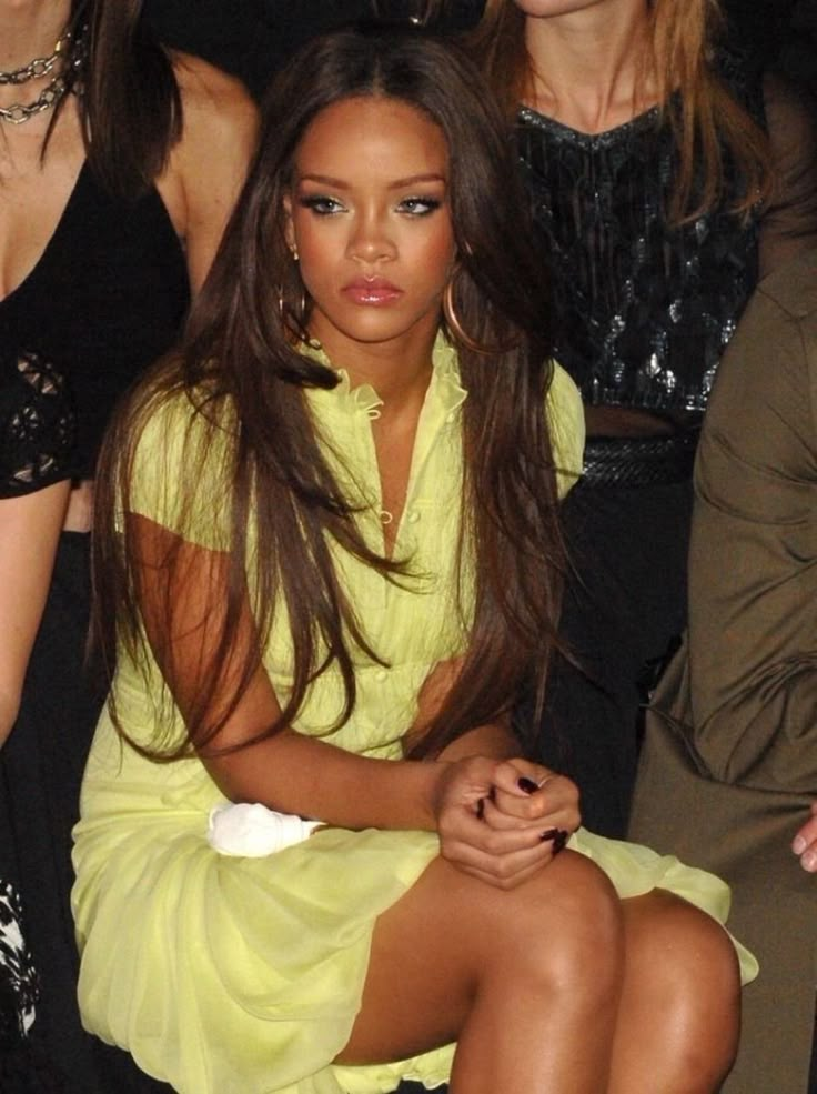 a woman sitting on top of a chair next to other women at a fashion show